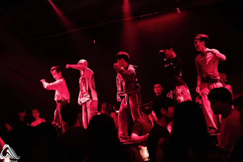Nhóm nhảy hip-hop biểu diễn trên sân khấu ALPHA dưới ánh đèn đỏ, khách vây quanh sát sàn